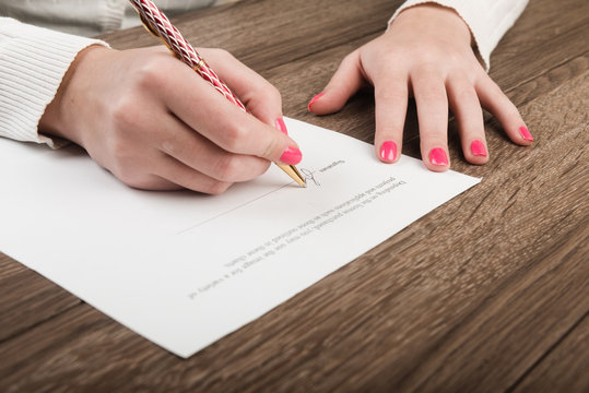 Businesswoman's hand with pen signing a contract.