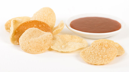 Poppadoms - Fried mini poppadoms on a white background. Served with chilli sauce.

