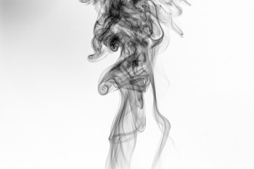 Abstract black smoke swirls over white background