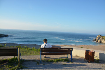 Naklejka na ściany i meble turista disfrutando de las vistas de la Playa de Usgo, Cantabria