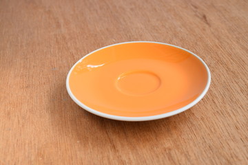 Empty orange plate on wood board