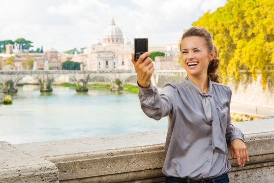Smiling woman taking selfie in Rome by Tiber River