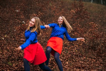Twin sisters in autumn forest