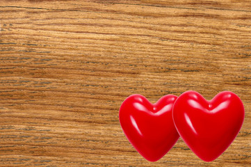 Two red hearts on wooden texture close-up background