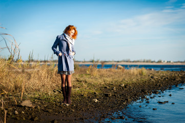 Red-haired girl on the bank of river