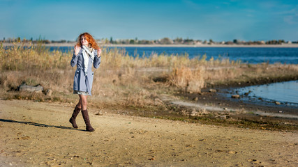 Red-haired girl on the bank of river
