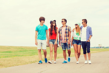 Obraz premium group of smiling teenagers walking outdoors