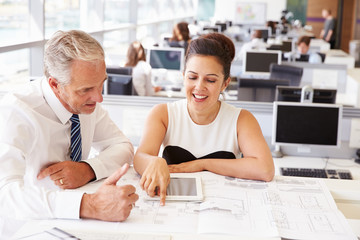 Male and female coworkers at a desk in an architect?s office