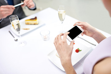 close up of couple with smartphones at restaurant