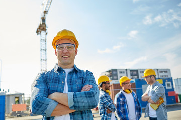 group of smiling builders in hardhats outdoors