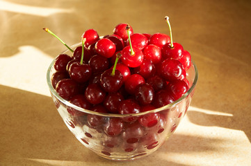 glass bowl full of red ripe cherries