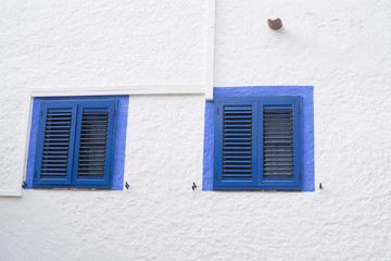 Two blue windows on a white wall