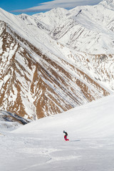 people tourists descend on a skateboard on snow-covered mountain
