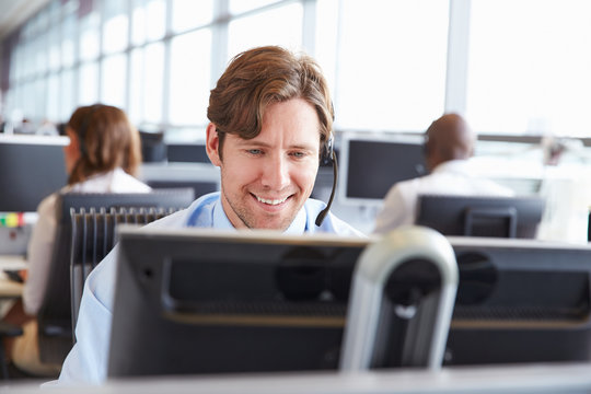 Male call centre worker, looking at screen, close-up