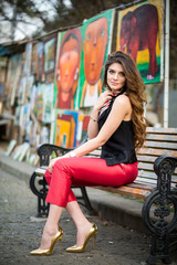 The beautiful young city woman sits on a bench