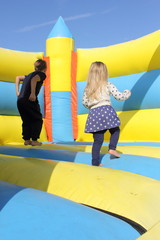 Children playing on a bouncy castle during the summertime