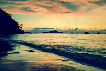 Obraz premium Vintage stylized photo of sunrise on the beach
