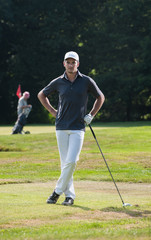 Obraz premium Close-up of a handsome golfer on the green during a sunny day.