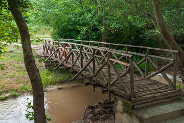 Wooden bridge over a stream  at a park trail