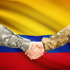 Men in uniform shaking hands with flag on background - Colombia