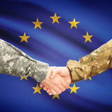 Men in uniform shaking hands with flag on background - Europe