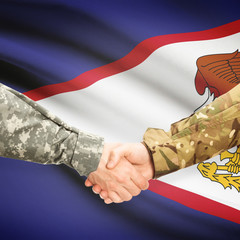 Men in uniform shaking hands with flag on background - American