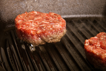 Fresh meat cutlets in a frying pan grill. CloseUp. Toned