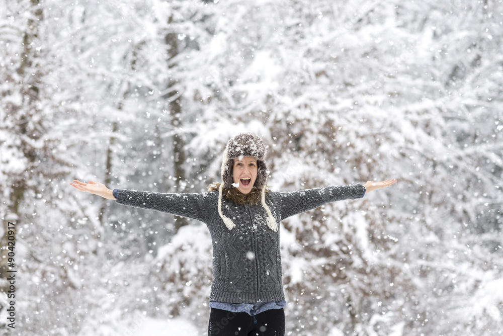 Wall mural excited young woman playing in snowy woods