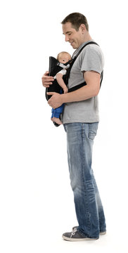 Glücklicher Vater trägt sein Baby in Babytrage