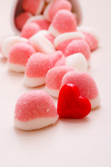 Pink jellies or marshmallows with sugar on table