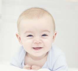 Baby with blue eyes looking to the camera and smiling