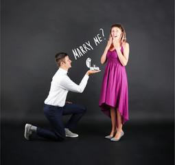 Romantic man proposing to a woman on black background