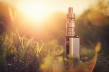 Adjustable electronic cigarette, Non carcinogenic alternative for smoking, sunset in the background
