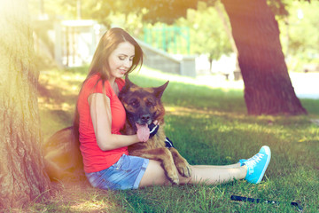 Beautiful young girl with dog in park