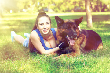 Beautiful young girl with dog in park