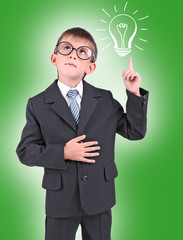 Little schoolboy with idea bulb above the head on green background