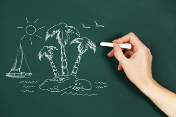 Female hand draw on blackboard with chalk, close up