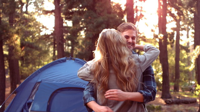 Couple hugging beside their tent