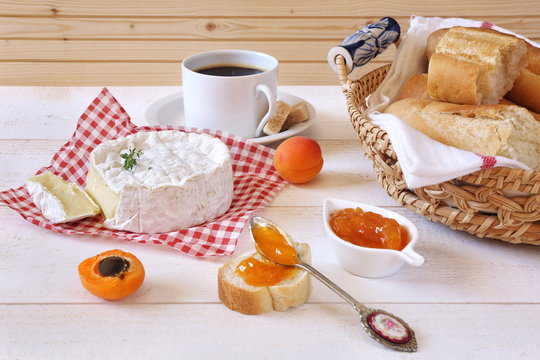 Camembert cheese, baguette, apricot jam and cup of coffee