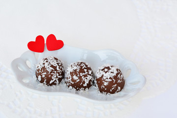 Chocolate candy with coconut flakes with red hearts
