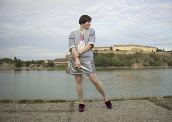Fashion blogger posing, ecletic style. Metalic, gray colors.