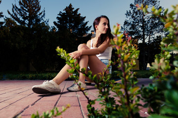 Women sitting on skateboard looking back