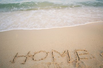 The word home written in sand on beach