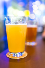 Beer glasses in the bar with bokeh light background