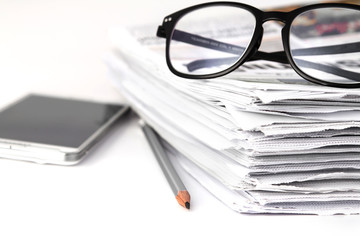 reading eyeglasses with stacking of newspaper background 