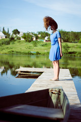 Fototapeta premium Young brunette girl flying her long gorgeous hair on bridge