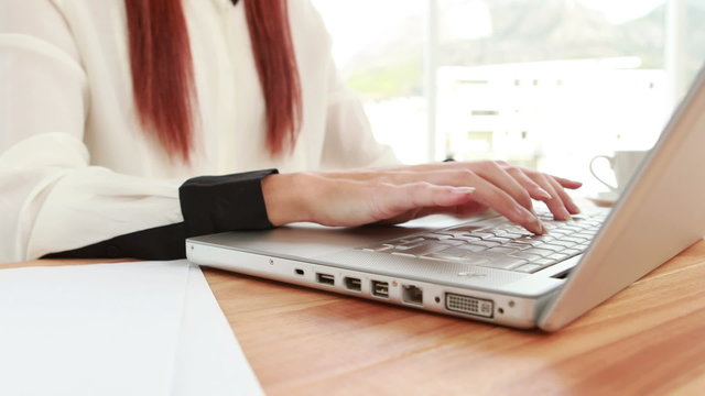 Red haired hipster using a laptop