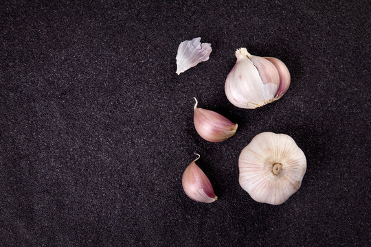  a still life arrangement of Three whole garlic bulbs grouped 