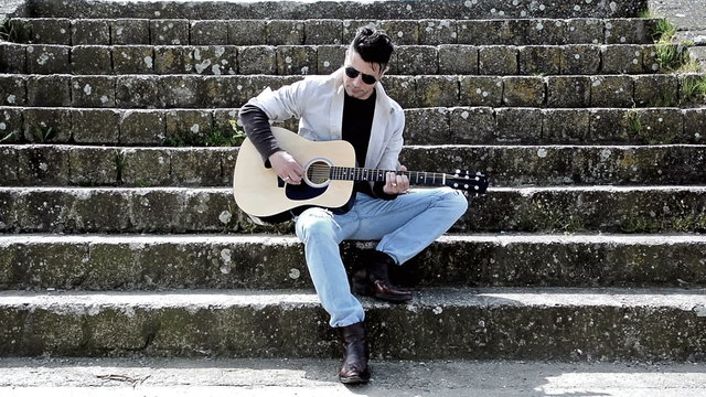 Man playing acustic guitar outdoors