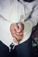 Hands praying with cross